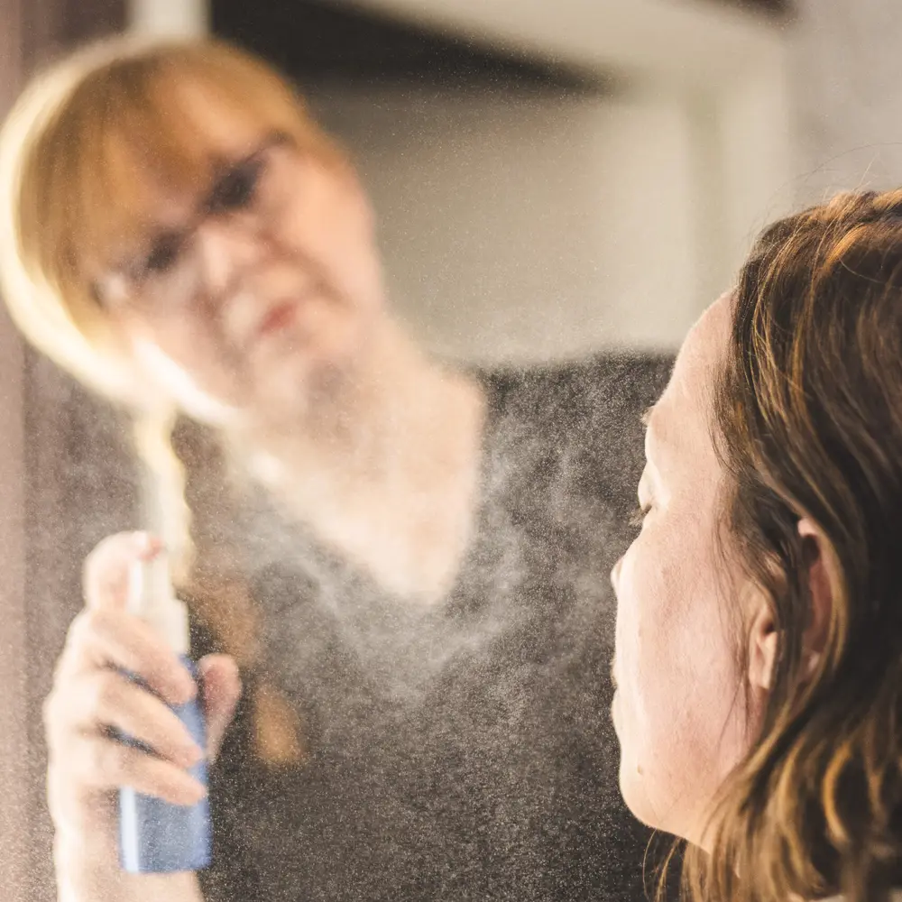 Veronica Strand fukter huden til en kunde med ansiktsspray